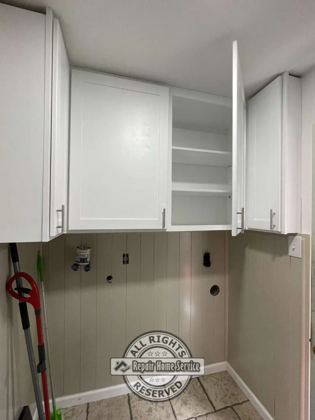 Built-in upper storage cabinets with adjustable shelving designed to maximize laundry room organization.