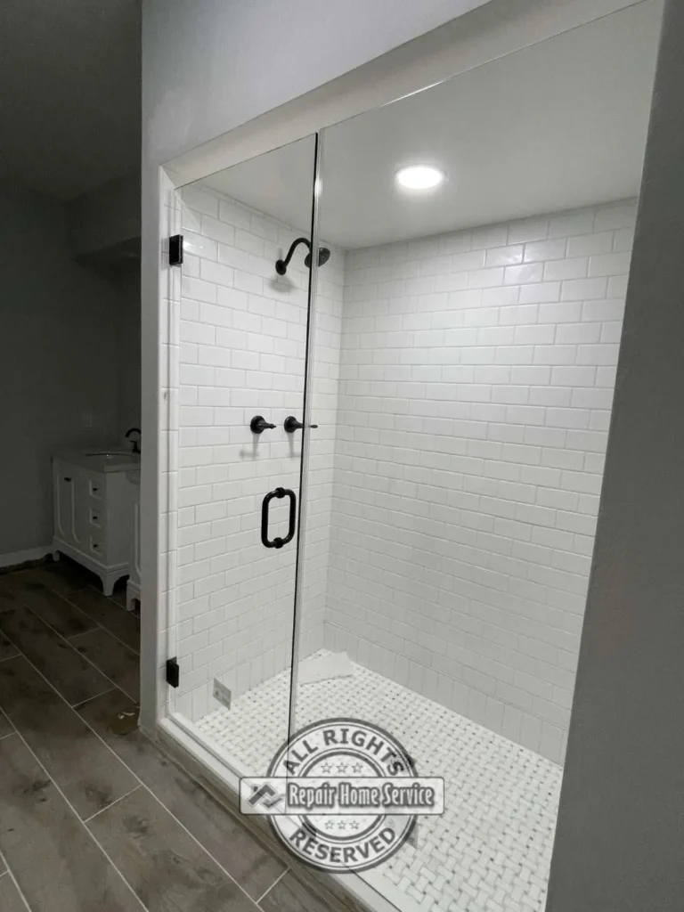 Completed bathroom remodel with freestanding soaking tub, gray wood-look tile flooring, and custom wall trim detail in Cypress TX