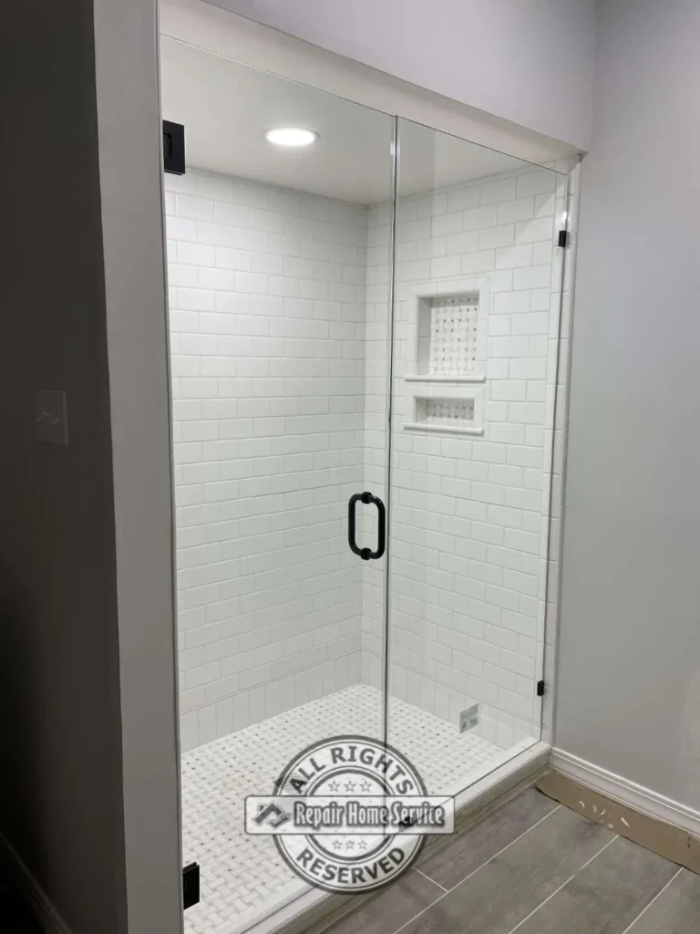 Finished bathroom remodel with white shaker vanity, modern fixtures, and custom shower enclosure in Cypress TX