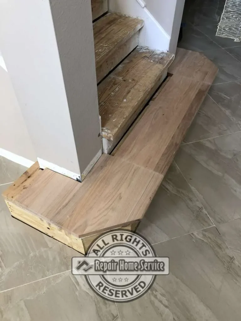 Unfinished solid Red Oak tread dry-fit on a custom wrap-around starter step with tight cuts around a drywall column during a Cypress TX staircase remodel.