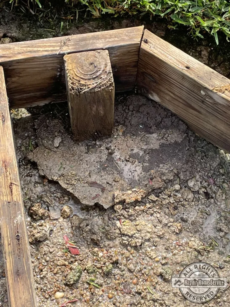 Deck support post set in muddy saturated soil showing foundation settling and moisture damage in Houston TX before rebuild.