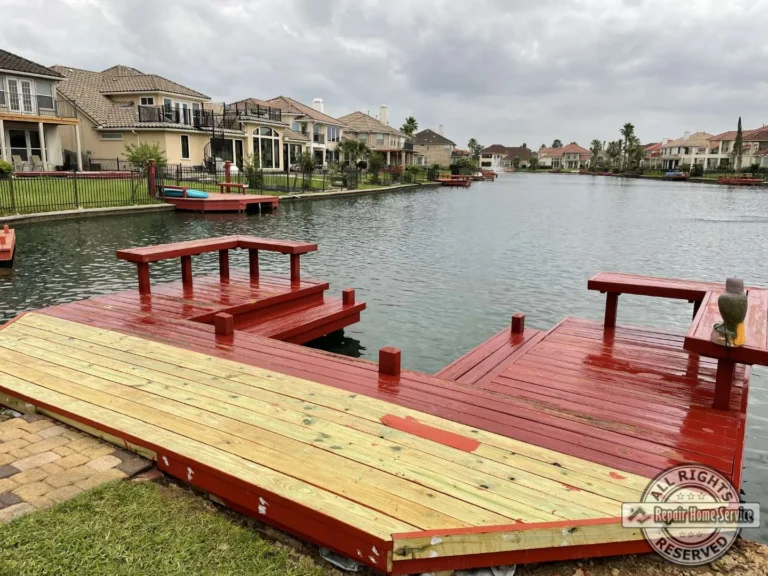 Mid-restoration lakeside deck in Houston TX with new pressure-treated decking beside finished red-stained platforms and built-in benches.