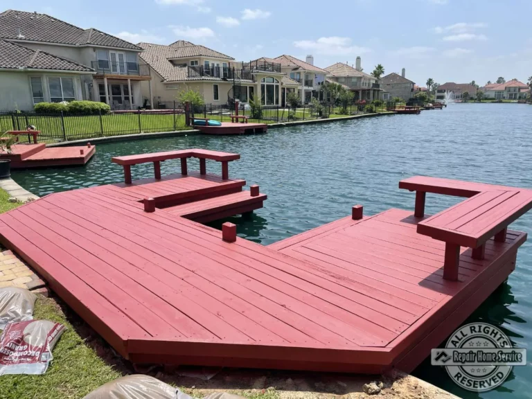 Completed red-stained waterfront deck restoration in Houston TX 77065 with multi-level platforms, benches, and lake views.