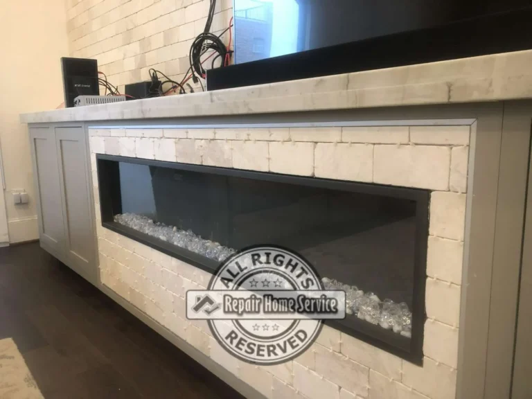 Close view of electric fireplace built into custom painted cabinet console with stone surround and granite top