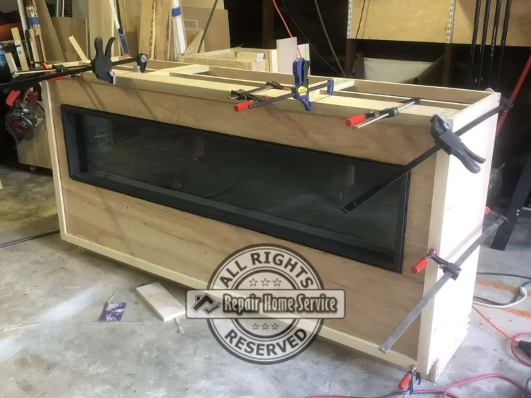 Workshop view of custom electric fireplace cabinet console being assembled with clamps before installation in Houston home