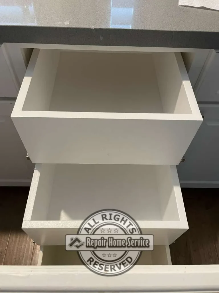 Close-up view of custom-built storage drawers installed within modified cabinet opening to maximize functionality and organization.