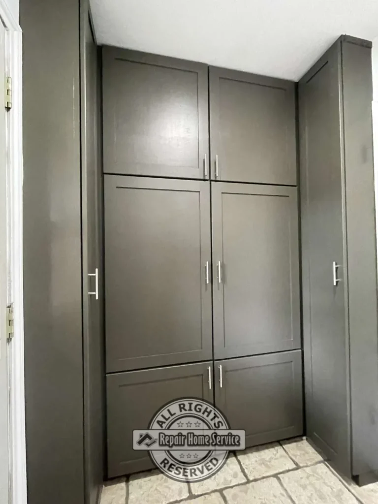 Tall custom utility cabinet with integrated shelving and concealed storage beside laundry appliances.