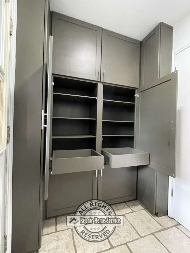 Original laundry room before renovation showing limited wall cabinets and exposed storage above washer and dryer.