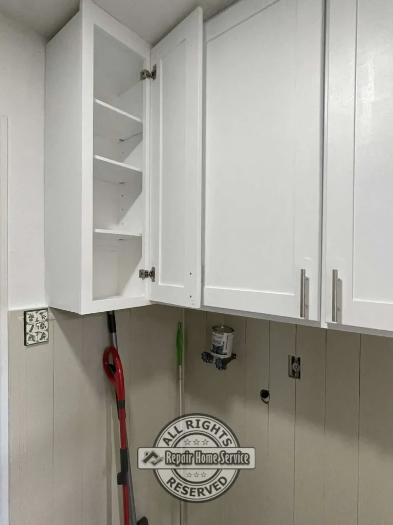Finished custom laundry room cabinet installation with shaker-style doors, shelving, and paint-grade finish in Houston Texas.