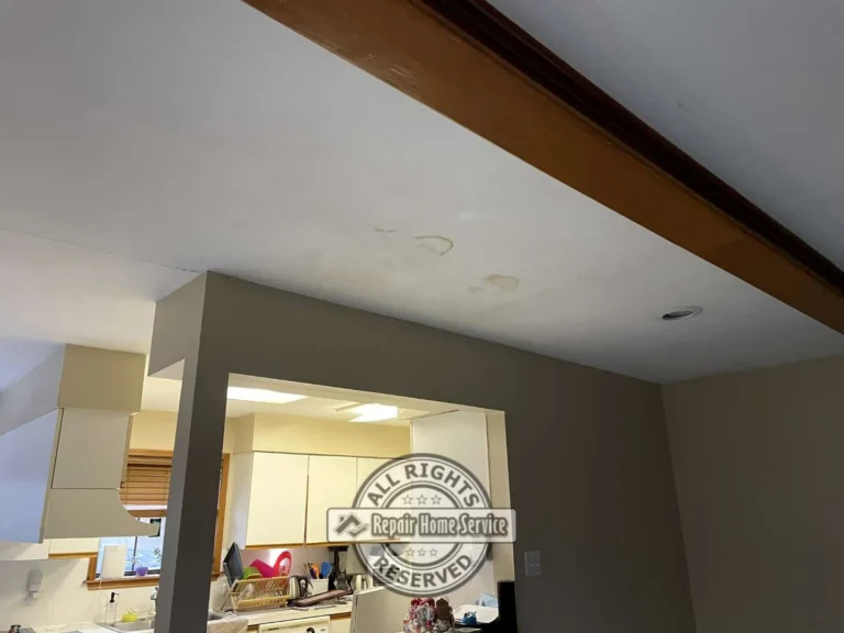 Water-damaged ceiling sections removed near kitchen and dining area with ladder setup during ceiling restoration project in Houston TX.