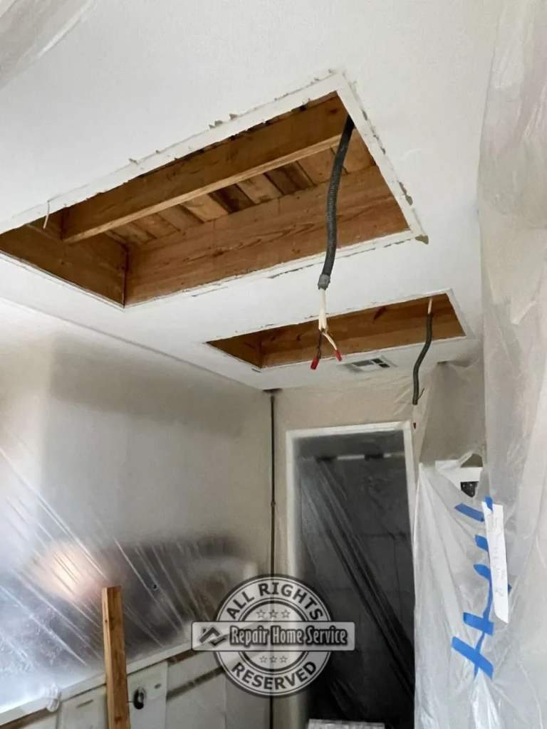 Hallway ceiling restoration with drywall finishing, recessed light openings, and plastic dust protection installed in Houston TX home.