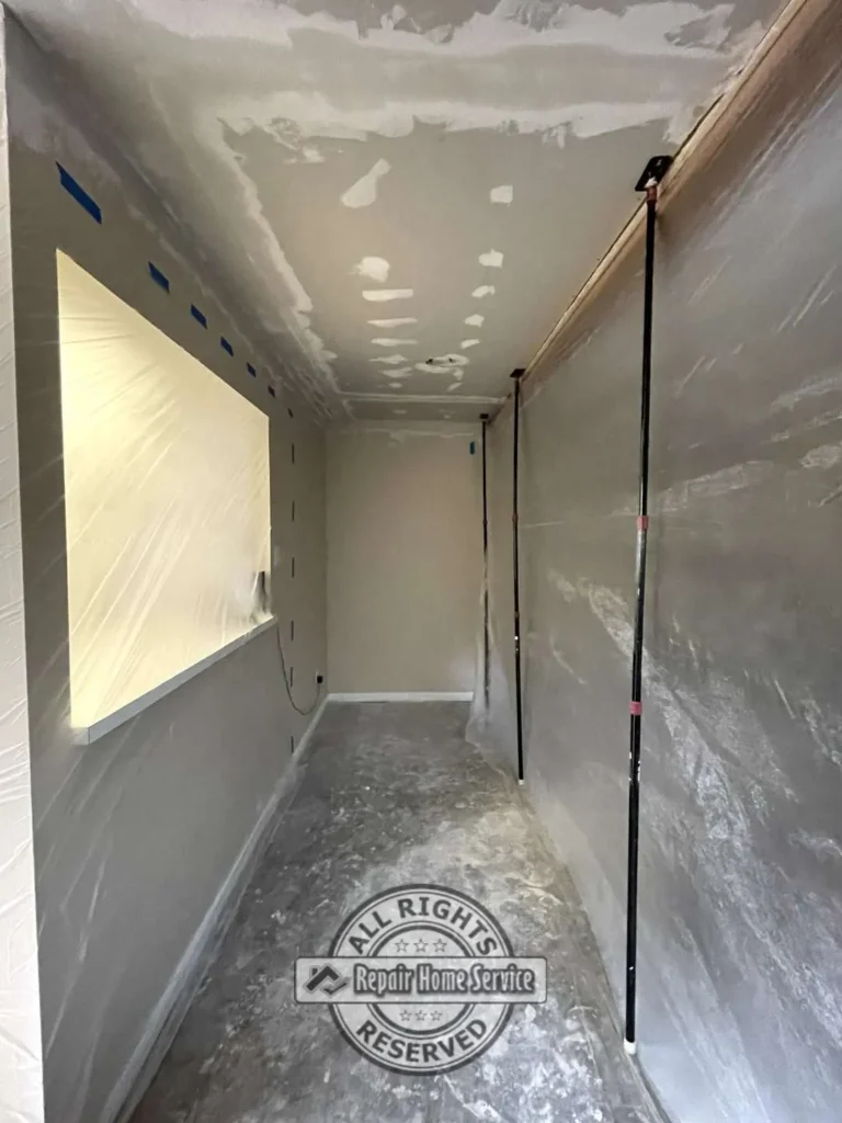 Ceiling restoration work in Houston TX showing drywall ceiling repairs and protective plastic covering around kitchen cabinetry after storm-related water damage.