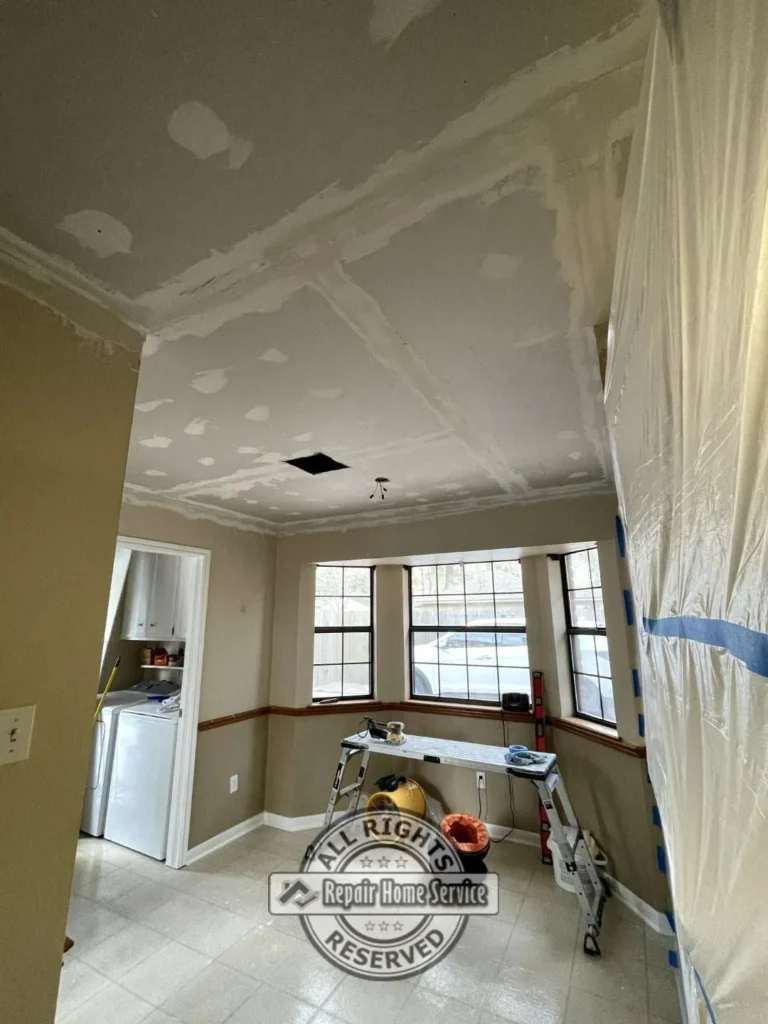 Drywall ceiling finishing and joint compound application in dining room area during Houston TX ceiling restoration project.